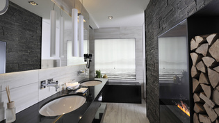 The picture shows an elegant bathroom decorated in dark tones.