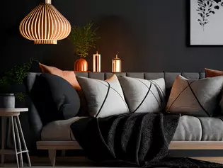 A stylish, minimalist living room with a cozy couch, decorative pillows and stylish lighting.