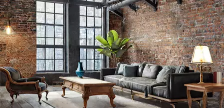 The picture shows a living room furnished in industrial style with antique furniture.