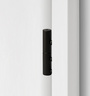 2-part wooden door hinge in the surface graphite black, shown in a white wooden door frame