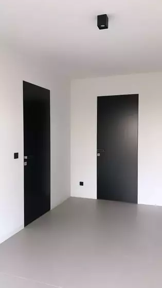 La ilustración muestra un pasillo de la Casa Negra con dos puertas en las que se ha instalado la Manillas de puerta FRAME de Griffwerk en Gris terciopelo.