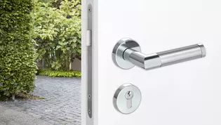 The illustration shows an entrance door with combination security fitting. On the outside a security fitting is mounted, on the inside of the interior door it is combined with a combination inner rose set and the GRIFFWERK handle Loredana.