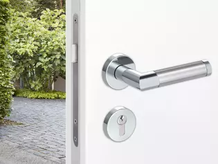 The illustration shows an entrance door with combination security fitting. On the outside a security fitting is mounted, on the inside of the interior door it is combined with a combination inner rose set and the GRIFFWERK handle Loredana.