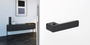 The image shows the Griffwerk door handle R8 One with a living room.