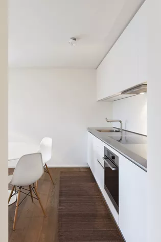 La imagen muestra una cocina con silla Eames