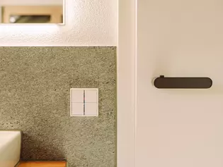 The picture shows the AVUS ONE door handle in cashmere grey in the bathroom.