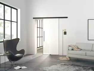 The picture shows a modern living room with the Planeo Air sliding door by Griffwerk on a wall.