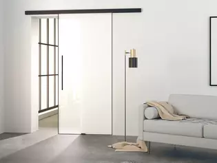 L'illustration montre un salon moderne avec la porte coulissante en verre Planeo AIR de Griffwerk sur un mur.