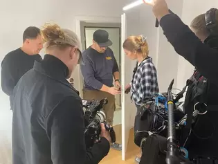 Videodreh Gewinnaktion mit die.tischlerin Die Abbildung zeigt wie zwei Tischler einen Türgriff an eine Tür montieren und dabei gefilmt werden.