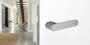 The image shows the Griffwerk door handle AVUS One with a living room.