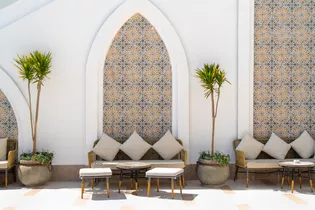 La foto muestra una terraza con mobiliario de estilo marroquí