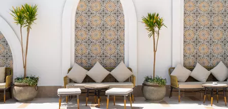 La foto muestra una terraza con mobiliario de estilo marroquí