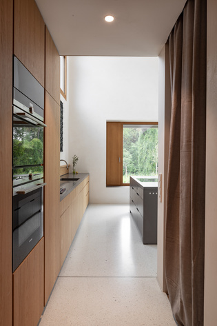 The kitchen monolith made of Corian in velvety black corresponds with the heavy, light grey curtains made of soft fabric. The door handle MINIMAL MODERN in velvet grey fits perfectly into the concept.
