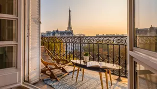 The photo shows a French interior of a flat with a view of a balcony in Paris.