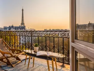 The photo shows a French interior of a flat with a view of a balcony in Paris.