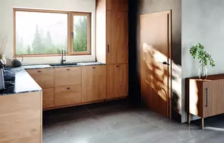 Auf der Abbildung ist eine Holzküche mit den neuen Griffen Aris zu sehen. Das Design des Griffes ist erhältlich als Türgriff, Fenstergriff und Möbelgriff.