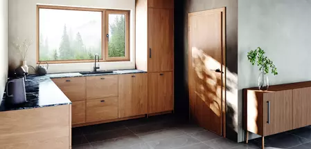 Auf der Abbildung ist eine Holzküche mit den neuen Griffen Aris zu sehen. Das Design des Griffes ist erhältlich als Türgriff, Fenstergriff und Möbelgriff.