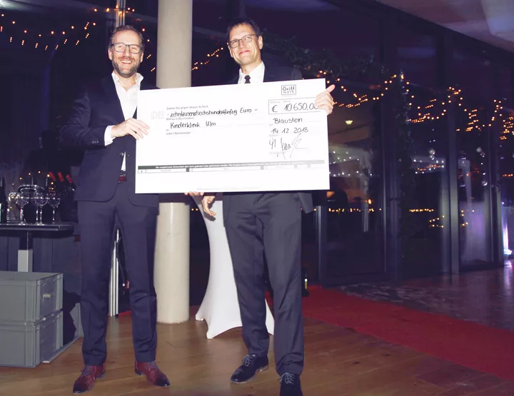 A check for 10650 euros was handed over at the Christmas party of GRIFFWERK GmbH for the "Time Donation" project of the Cystic Fibrosis Outpatient Clinic of the Ulm Clinic for Pediatrics and Adolescent Medicine. (from left: Matthias Lamparter, Managing Director of Griffwerk GmbH; PD Dr. Peter Meißner, Senior Physician and Head of the Cystic Fibrosis Outpatient Clinic of the Ulm Clinic for Pediatrics and Adolescent Medicine) (Photo: GRIFFWERK GmbH)