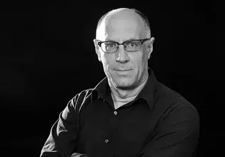 Die Abbildung zeigt ein Portrait von dem Designer Oliver Fischer in schwarz weiss.