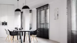 The illustration shows a dining room in black and white darkened by matching black blinds.