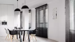 L'illustration montre une salle à manger en noir et blanc obscurcie par des stores noirs assortis.