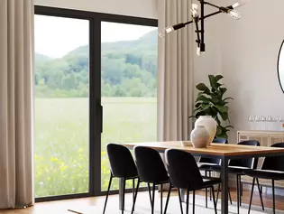 The illustration shows a dining room with lift-and-slide door and black Lucia lift-and-slide door handle from Griffwerk.