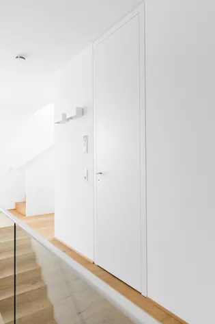 The staircase to the first floor integrates harmoniously without changing the floor material and was only delimited by a transparent glass wall.