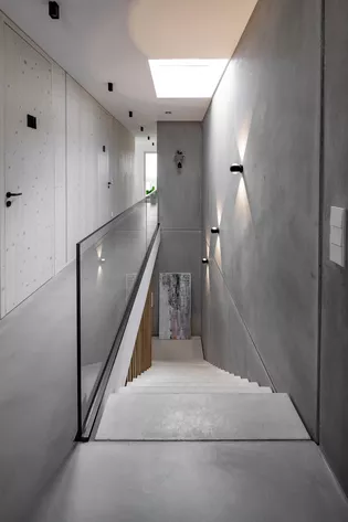 Portes pivotantes à hauteur de pièce avec poignées ULMER GRIFF dans la maison Donautal À l'intérieur de la maison Donautal, les portes pivotantes à hauteur de plafond mettent parfaitement en valeur la ferrure de porte ULMER GRIFF de Max Bill.