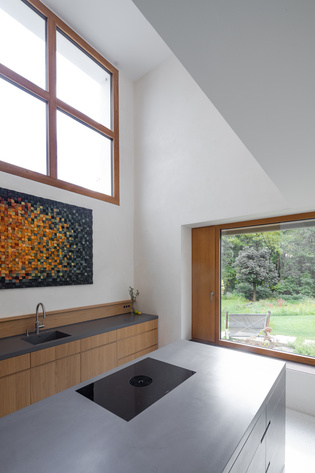 Above the kitchen, a light space gives sacred height. A large window illuminates it.