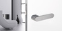 The image shows the Griffwerk door handle AVUS One with a living room
