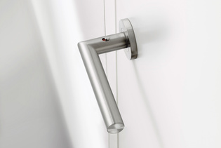 The picture shows the door handle Lucia in stainless steel mounted on a white wooden door.